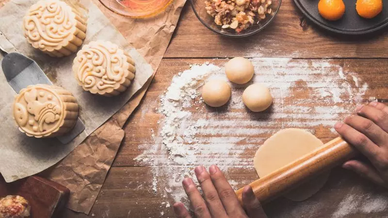 Cán bột mỏng và bọc kín nhân hạt sen và trứng muối